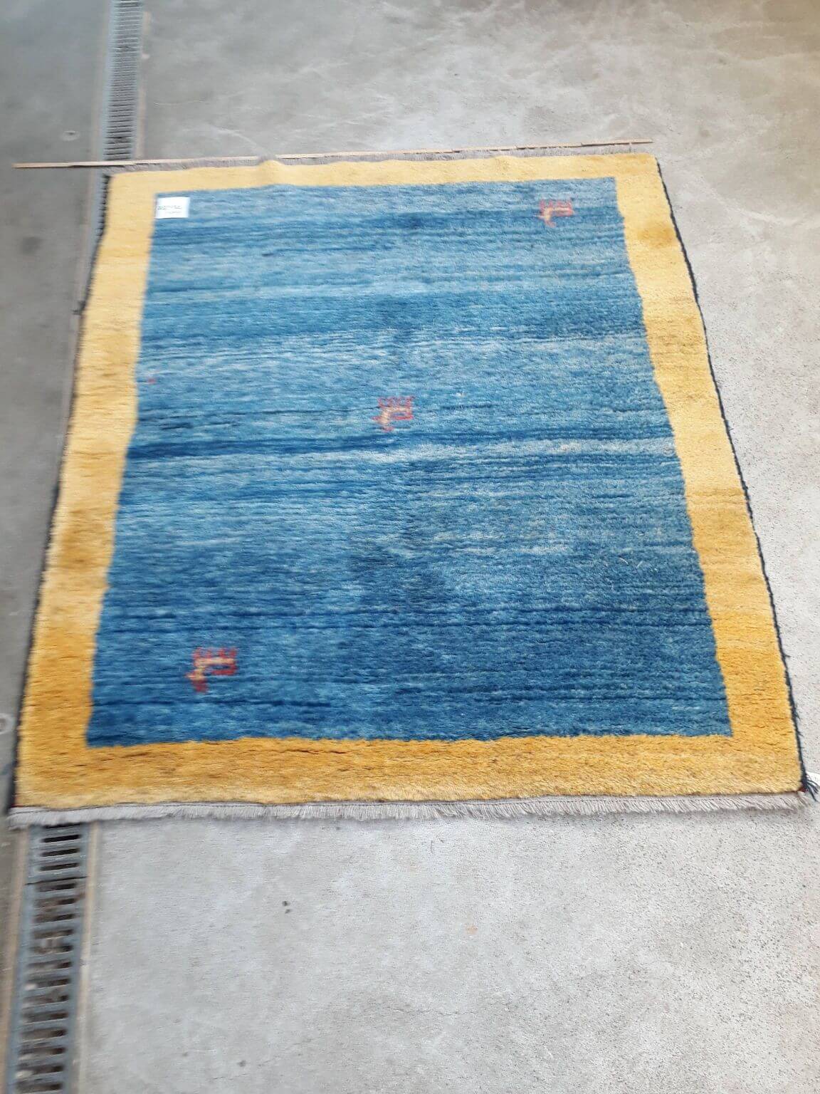 blauer Teppich mit gelber Rahmung