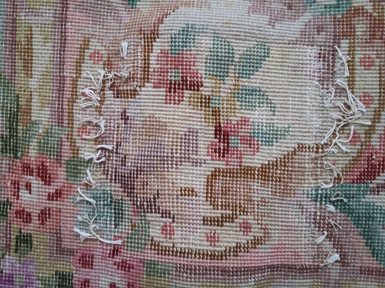 Rückseite mit Ausbesserungsarbeit des Teppichs mit floralem Muster