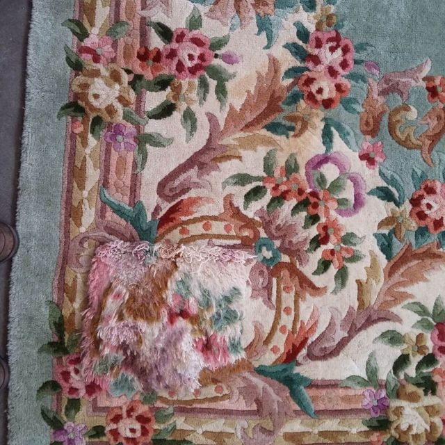 Schadstelle auf floralem Musterteppich